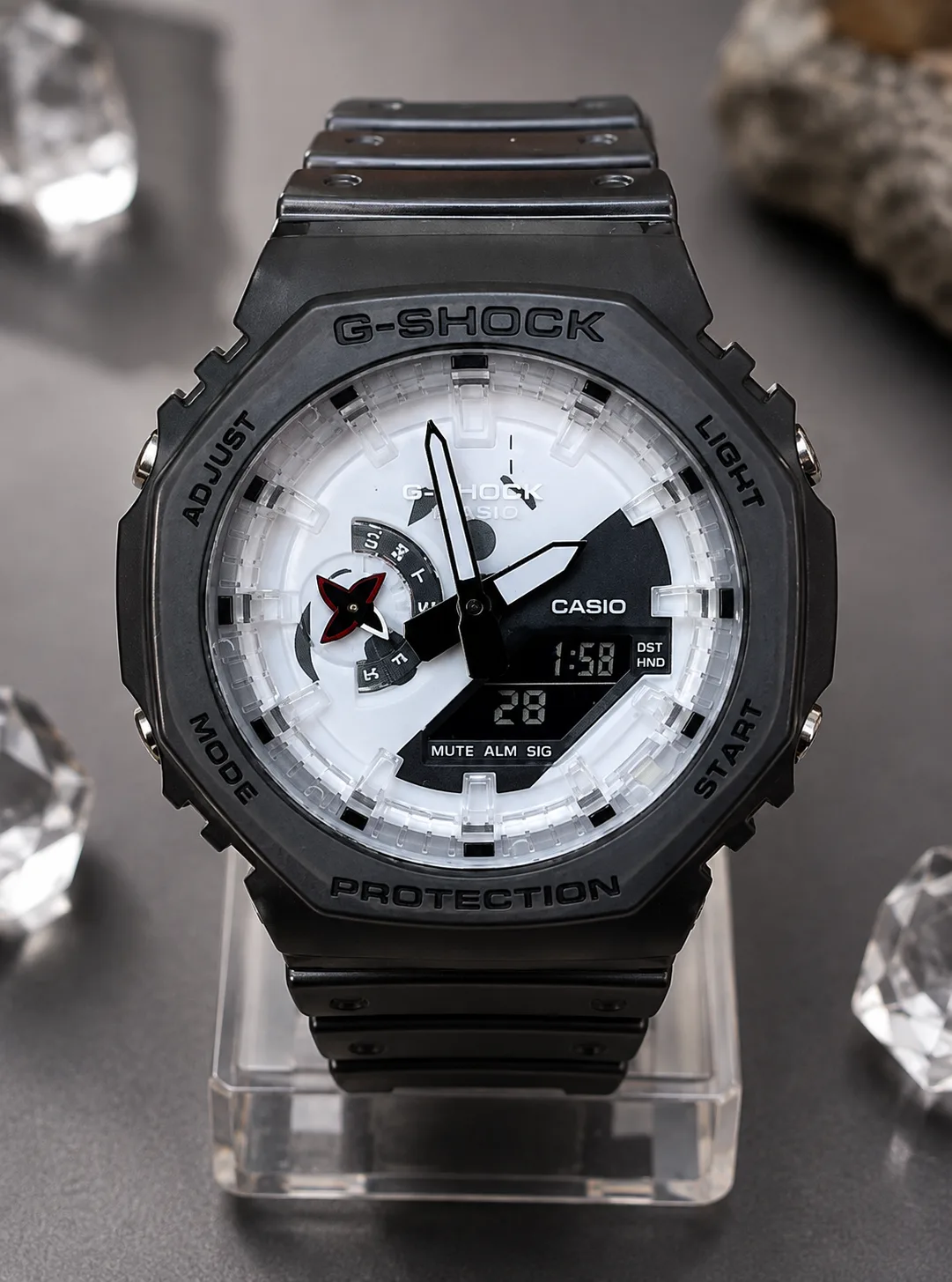 GA-2100NNJ-8A, de face : boîtier en résine grise translucide, motif de maille estampé, cadran blanc et noir, étoile de shuriken rouge au compteur des jours.