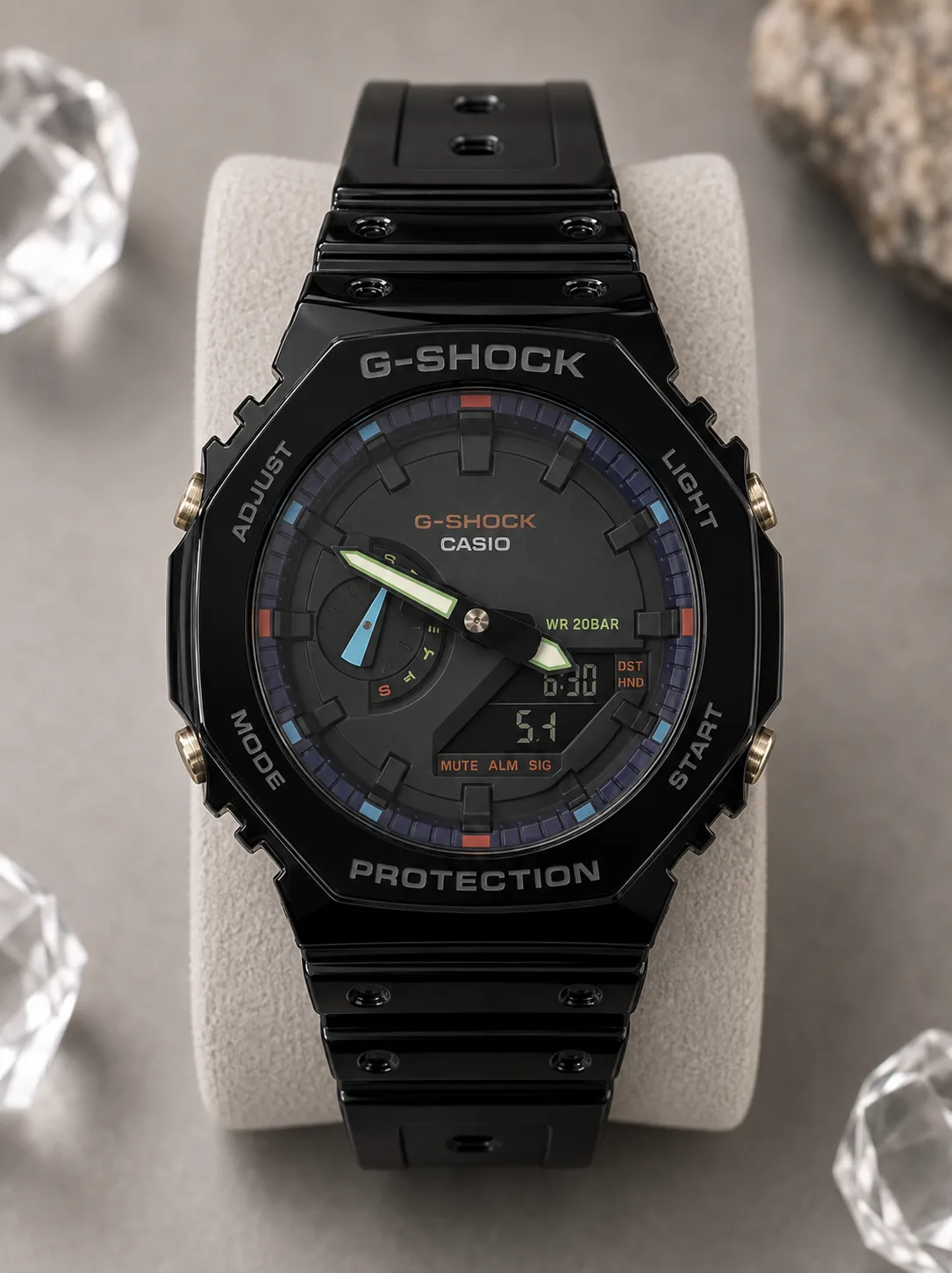 GA-2100RGB-1A, de face : boîtier en résine noire brillante, cadran noir, index et rehauts multicolores, aiguilles contrastées.